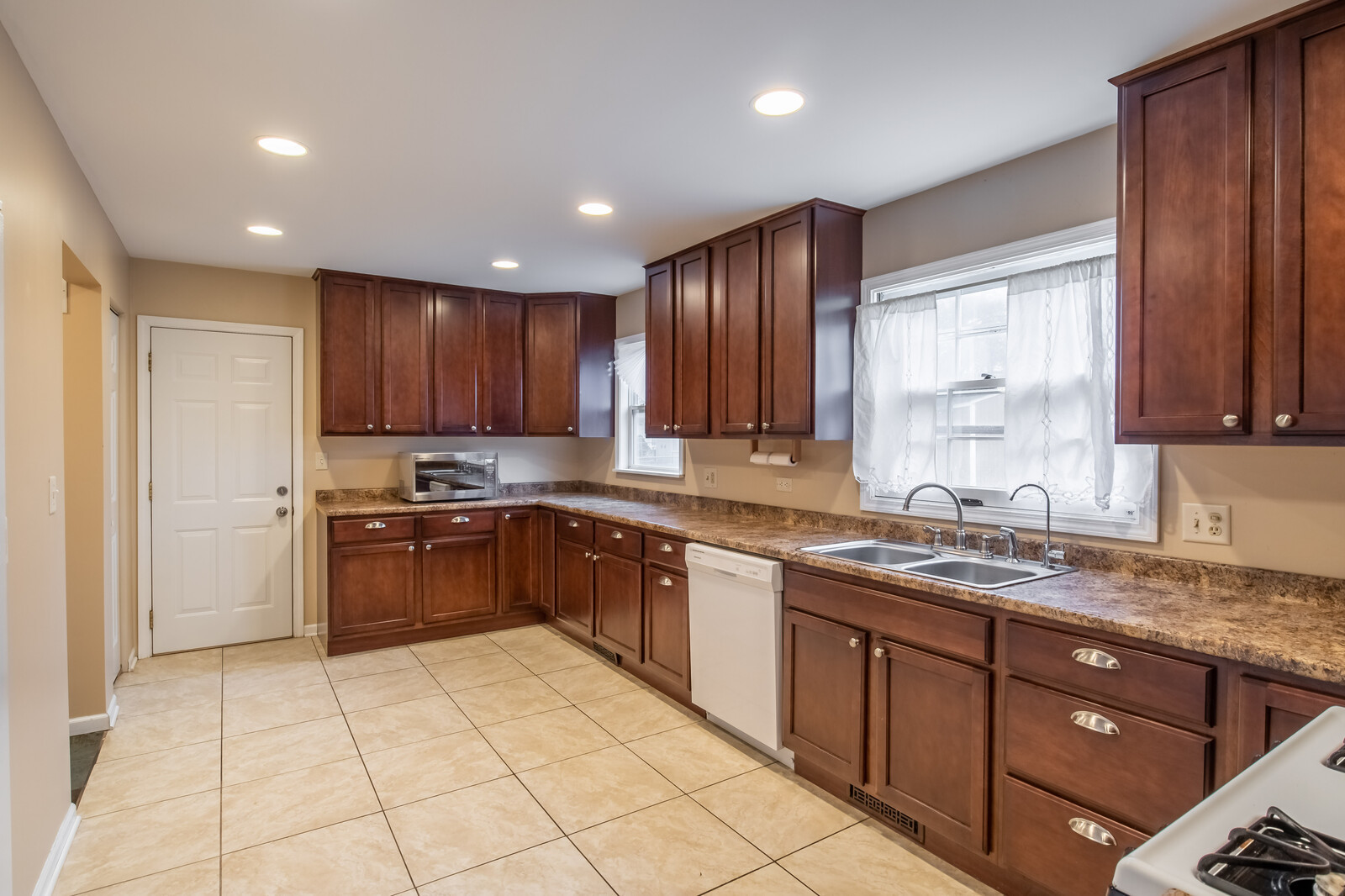 2321 Beck Road Lindenhurst, IL 60046 - Photo 7 of 30 a kitchen with kitchen island granite countertop wooden cabinets stainless steel appliances a sink and a window
