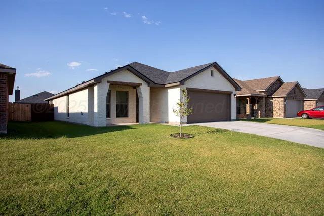 a front view of a house with yard and garage