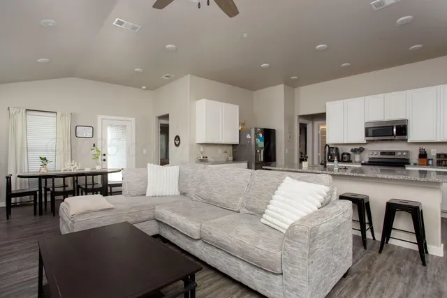 a living room with kitchen island furniture and a flat screen tv