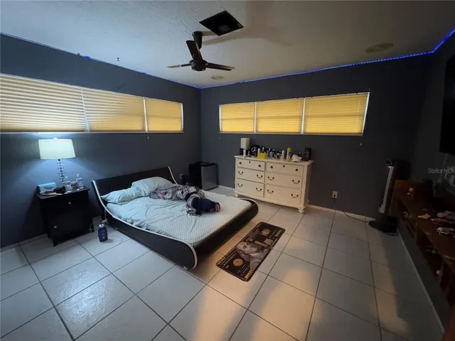 a backyard of a house with table and chairs and potted plants