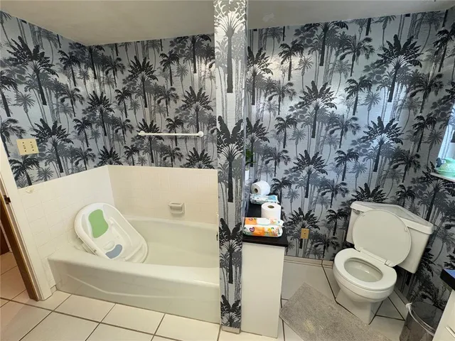 a white toilet sitting next to a white wall