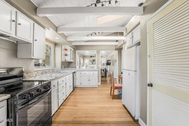 a kitchen with granite countertop cabinets stainless steel appliances and a counter space