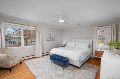 a spacious bedroom with a bed a dresser and next to a window