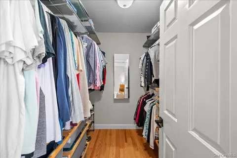 a view of walk in closet with clothes and shoes