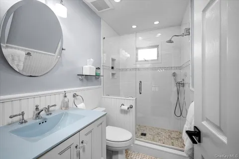 a bathroom with a sink a toilet and shower