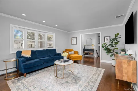 a living room with furniture a flat screen tv and a table