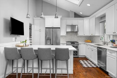 a kitchen with stainless steel appliances kitchen island granite countertop a table and chairs