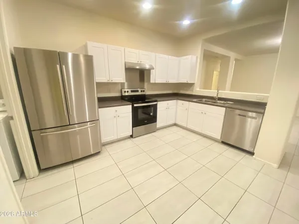 a kitchen with stainless steel appliances granite countertop a refrigerator sink and cabinets