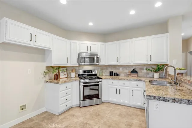 a kitchen with granite countertop a sink stove and cabinets