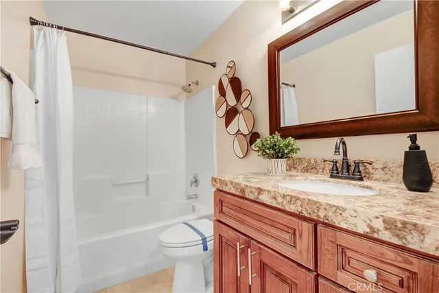 a bathroom with a granite countertop sink a mirror and a bathtub