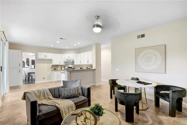 a living room with furniture and a dining table with kitchen view