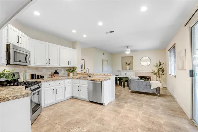 a large white kitchen with cabinets and chairs