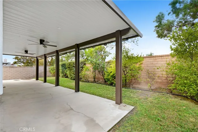 a view of a porch with a big yard potted plants and floor to ceiling window