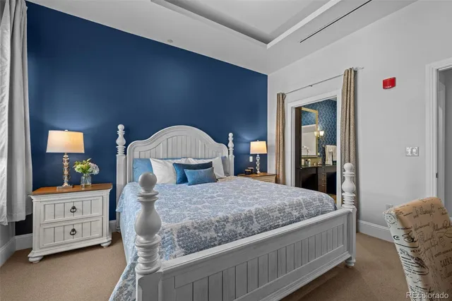 a bedroom with a bed a lamp and dresser