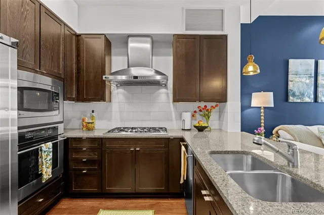 a kitchen with stainless steel appliances granite countertop a sink stove and refrigerator
