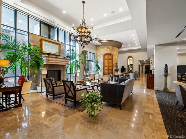 a living room with furniture a fireplace and a chandelier