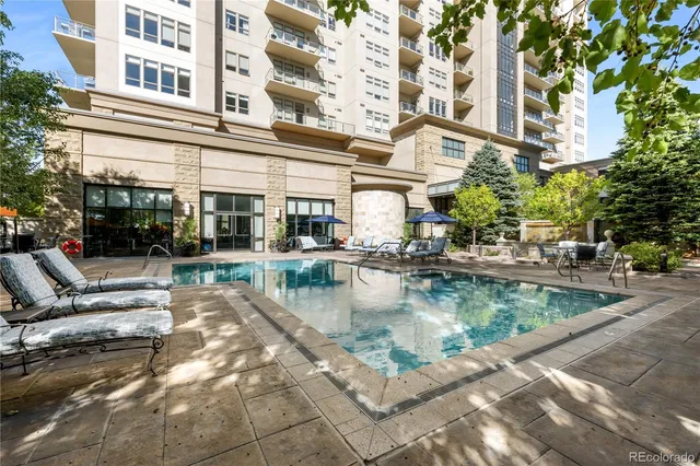 a view of a building with pool and chairs