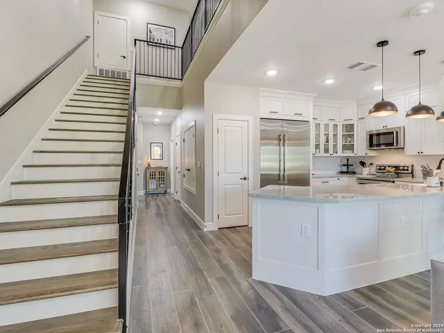 a open kitchen with white cabinets and stainless steel appliances