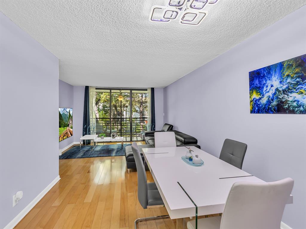 7579 Northwest 79th Avenue, Unit 204 Tamarac, FL 33321 - Photo 14 of 45 a view of a dining room with furniture wooden floor and a large window
