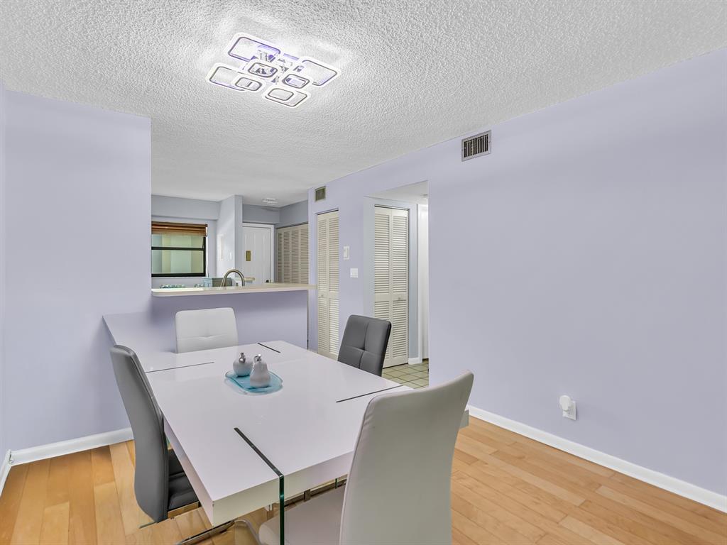 7579 Northwest 79th Avenue, Unit 204 Tamarac, FL 33321 - Photo 16 of 45 a view of a dining room with furniture and wooden floor