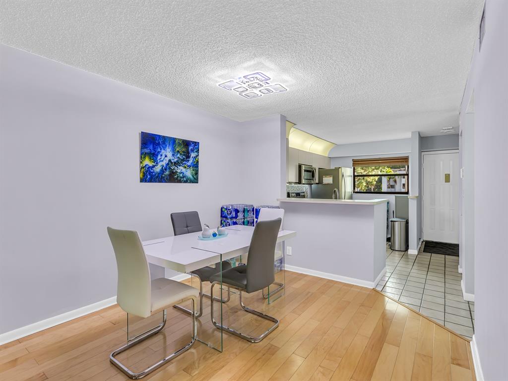7579 Northwest 79th Avenue, Unit 204 Tamarac, FL 33321 - Photo 17 of 45 a view of a dining room with furniture and wooden floor