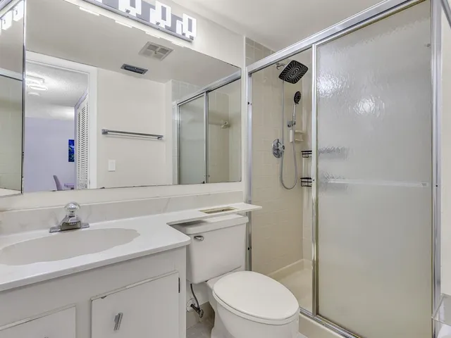 a bathroom with a sink toilet vanity and shower