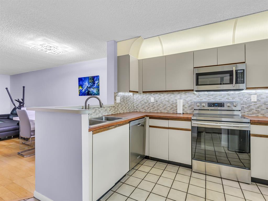 7579 Northwest 79th Avenue, Unit 204 Tamarac, FL 33321 - Photo 7 of 45 a kitchen with stainless steel appliances granite countertop a sink and a microwave