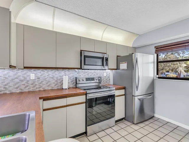 a kitchen with stainless steel appliances a refrigerator sink and microwave