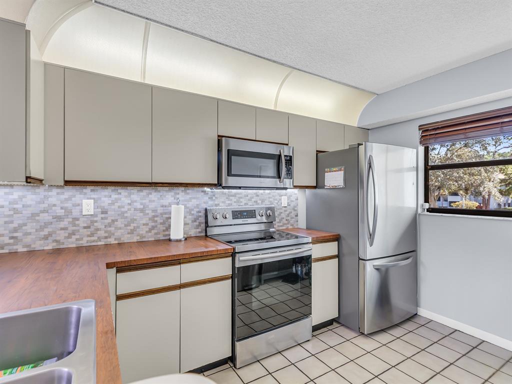 7579 Northwest 79th Avenue, Unit 204 Tamarac, FL 33321 - Photo 8 of 45 a kitchen with stainless steel appliances a refrigerator sink and microwave