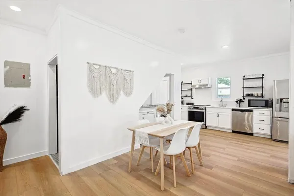 a kitchen with a dining table chairs and white stainless steel appliances