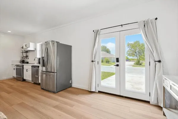 a kitchen with a refrigerator and a wooden floor