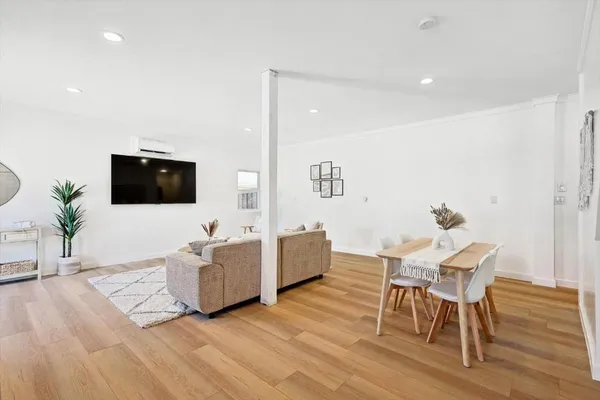 a living room with furniture a flat screen tv and a wooden floor