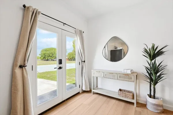 a view of a livingroom with a potted plant and wooden floor