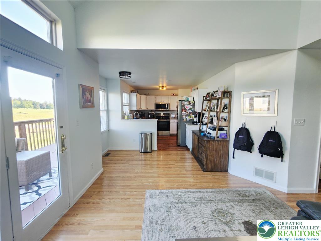 237 Ridings Circle Macungie, PA 18062 - Photo 23 of 70 Gleaming hardwood floors and a vaulted ceiling elevate this open-concept layout leading to the kitchen.