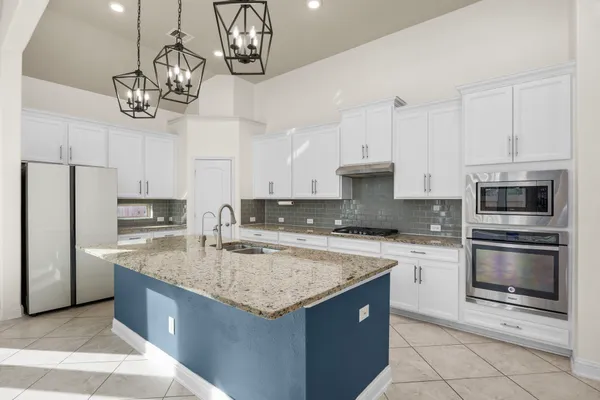 a kitchen with a center island appliances and cabinets