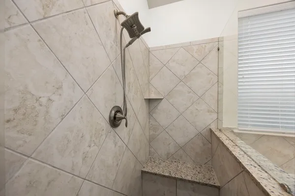 a bathroom with a granite countertop sink and a shower