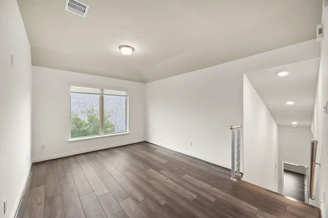 a view of an empty room with wooden floor