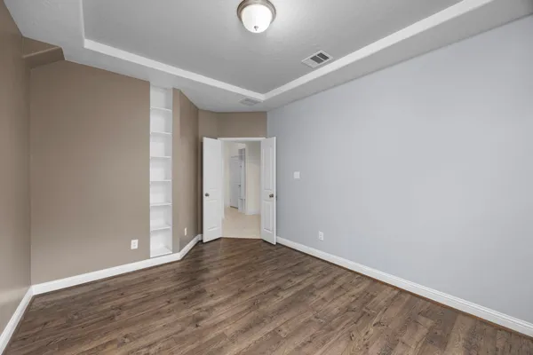 a view of an empty room with wooden floor