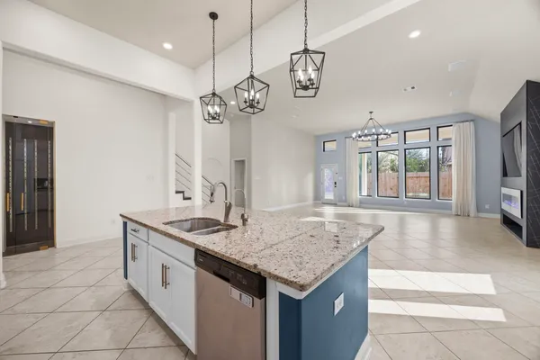 a hall with kitchen island granite countertop a sink and a stove