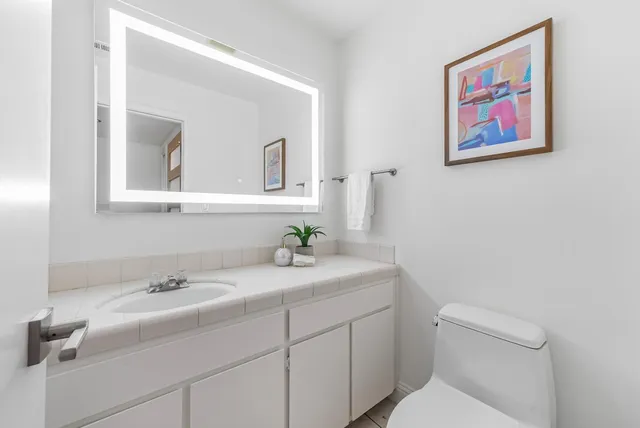 a bathroom with a toilet sink and mirror