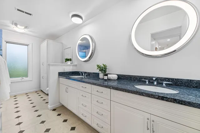 a bathroom with a granite countertop sink and a mirror