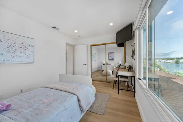 a bedroom with furniture and a large window