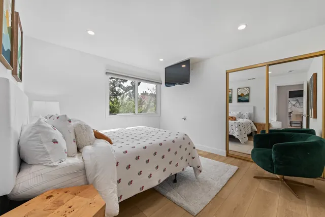 a bedroom with a bed and wooden floor