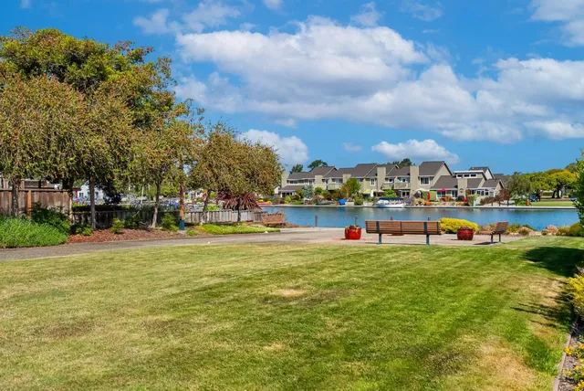 a view of a roof deck with table and chairs a barbeque with wooden floor and fence