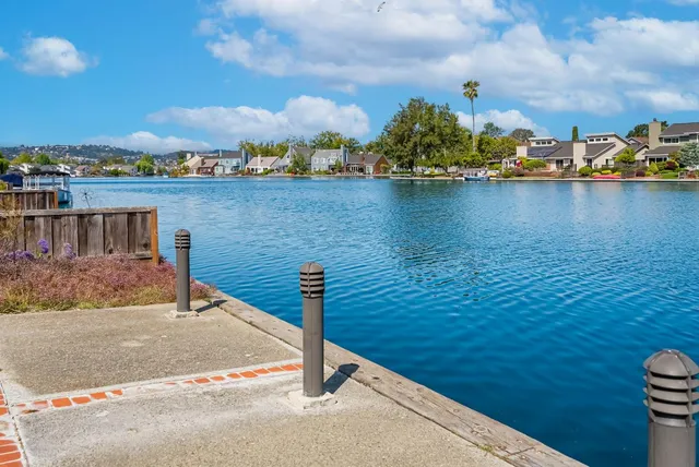 a view of a patio with a dining table and chairs with wooden floor and fence