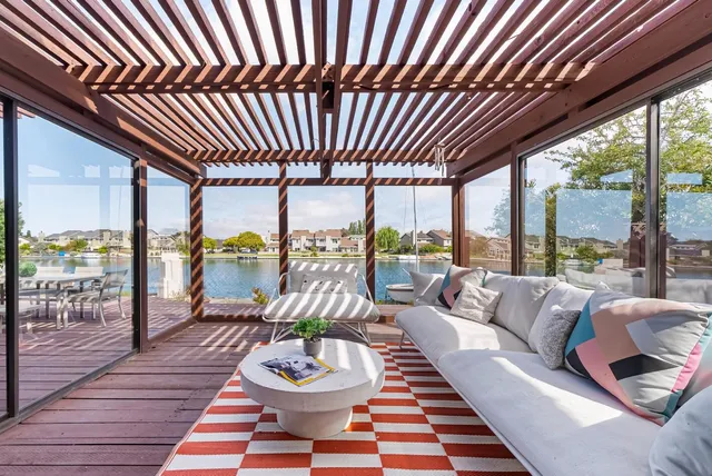 a view of a roof deck with table and chairs under an umbrella with wooden floor