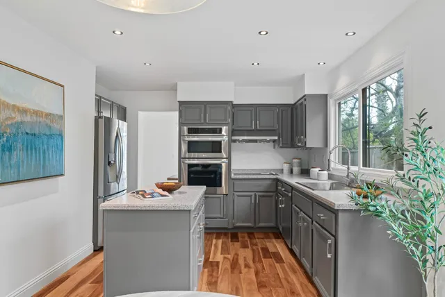 a kitchen with stainless steel appliances a sink stove and cabinets