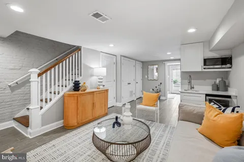 a living room with furniture and a dining table with wooden floor