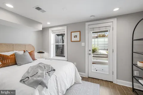 a bedroom with a large bed and wooden floor