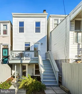 a view of a house with a deck and furniture